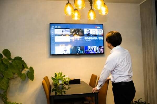こだわりのシャンデリアだけではく、壁にはネット接続されたモニターが。不動産屋とは思えない内装だ
